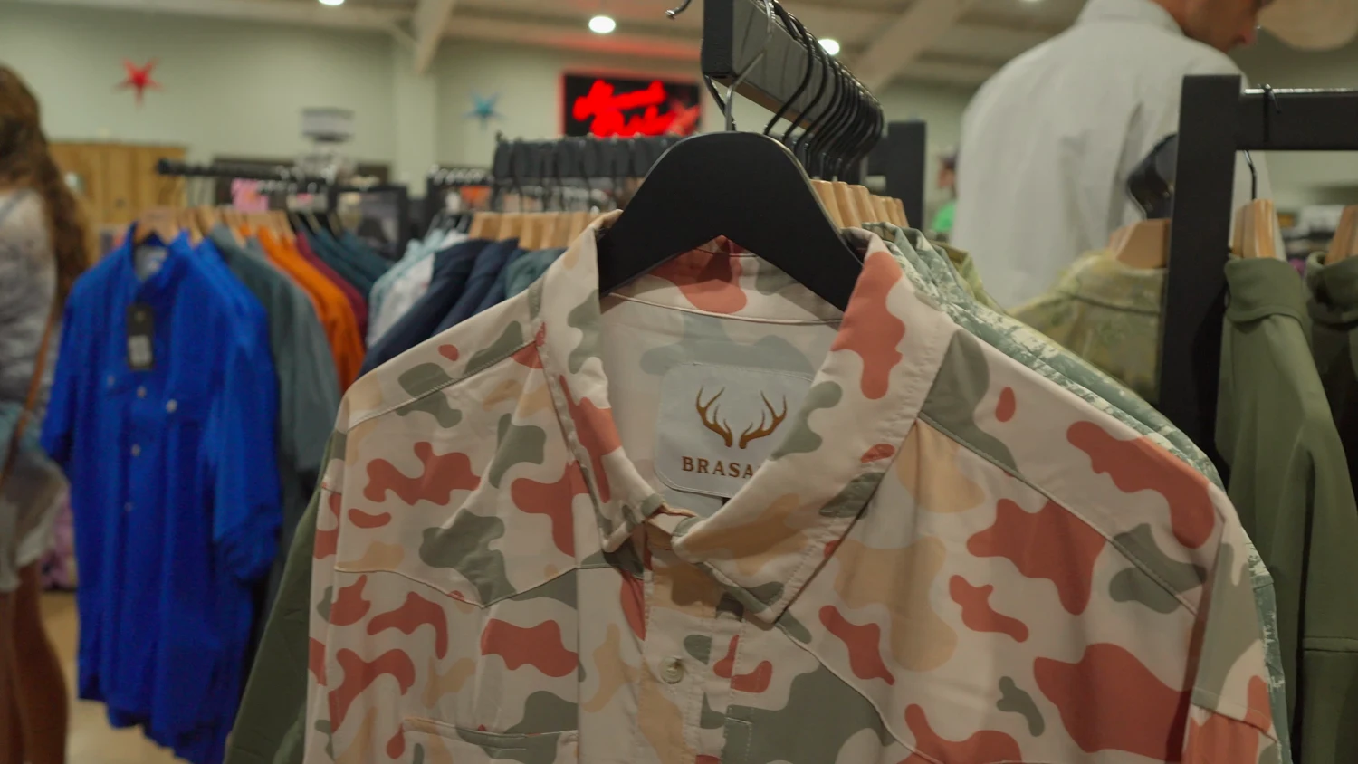 Patterned and camouflage shirts hanging on a rack in the Mumme's apparel department